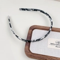 Détail d'un serre-tête en acétate avec dents antidérapantes et texture marbrée - Noir et Blanc