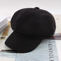 Classic black newsboy cap in textured fabric resting on magazines in a stylish setting - One Size 58cm / Black Twill Octagonal Hat
