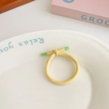 Single yellow elastic hair tie with green plastic tips on a white display plate - Yellow