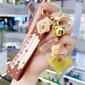Cartoon brown bear milk tea keychain featuring yellow floating liquid and a gold bell - Pearl Milk Tea Bear-Flat Candy