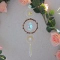 Detailed shot of golden metal moon frame and sparkling rainbow crystal suncatcher - Tiger's Eye