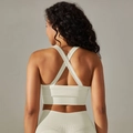 Detail des nahtlosen cremeweißen Sport-BHs mit überkreuztem Rückendesign und Textur - S / Creme