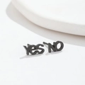 Gros plan de boucles d'oreilles asymétriques noires Yes et No sur fond blanc pur - Noir