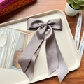 Taupe satin double bow hair clip on a beige tray with decorative accessories - Dark Grey 162