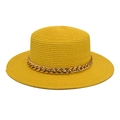 Detail of a bright yellow straw flat top hat featuring a chunky gold chain accessory - Yellow
