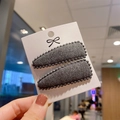 Detail of dark grey felt hair clips with bead trim on a white card display - Dark Gray