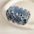 Close-up of blue leopard print resin links on a minimalist beaded stretch bracelet - Blue