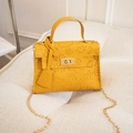 Detail of yellow PU leather bag with graffiti embossing, gold lock and chain strap - Yellow