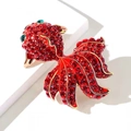 Close-up of a sparkling goldfish brooch with red crystals and green gemstone eyes - Goldfish Style