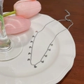 Silver butterfly necklace with mini charms on white plate with pink tulips background - Butterfly / Silver