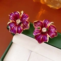 Nahaufnahme von Vintage-Blumenohrringen mit lila Emaille und funkelnden Kristallen - Ohrclip-Stil (Mit Silbernadel) / Lila/Gold
