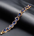 Bracelet doré avec cristaux en forme de gouttes bleues étincelantes et petits strass clairs - Bleu