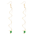 Detailed view of long gold spiral wire earrings featuring green beads and wave design - Green Bead Spiral Earrings / Green