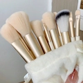 Golden makeup brush set with beige bristles and a white plush drawstring storage pouch - 13Pcs Beige + Cloth Bag