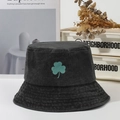Washed black denim bucket hat featuring green clover embroidery and metallic eyelets - Black