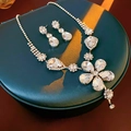 Exaggerated floral silver necklace and earring set with shimmering crystals on green box - Silver Flower Teardrop Rhinestone Style