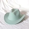 Detail of mint green felt fedora hat with white stitched brim on white fabric background - Mint Green