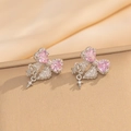 Detail of silver bow earrings with pink heart gemstones and dangling star charms - Silver Pink Stud Earrings