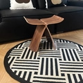 Modern wooden butterfly stool in natural finish on a geometric round rug and sofa scene - Diameter 80cm / Ascending Steps Pattern Round