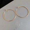 Macro view of gold-plated hoop earrings with transparent clip-on silicone pads - 6cm / Gold / Clip-On Earrings