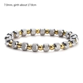 Detail of 7mm two-tone gold and silver beaded elastic bracelet with diamond-cut texture - 7mm Bead Diameter / Gold + Silver