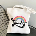 White canvas tote bag featuring a rainbow print and Teacher graphic on a chair - STD374-O Art Word Rainbow/Teacher