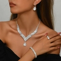 Detailansicht des silbernen Brautschmuck-Sets mit funkelnden Straßsteinen am Model - Silber (Halskette+Ohrringe+Armband+Ring)