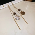 Detail von langen Quastenohrringen mit Goldfinish, braunen Perlen und weißen Muschelscheiben - Ohrhaken - Gold - Braun