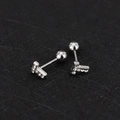 Macro detail of silver screw-back stud earrings with pave-set zircon stones - T Letter - Steel