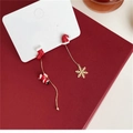 Gros plan de boucles d'oreilles de Noël asymétriques avec Père Noël, bottes et flocons - Style Botte Rouge et Bonnet de Noël