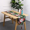 Dettaglio del runner da tavola natalizio con motivi di Babbo Natale e nappe rosse - Stile A Babbo Natale