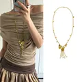 Franse vintage gouden schelp kwastje ketting met hartbedels en parelaccenten - Gouden Kwastje Schelp Hart Stijl