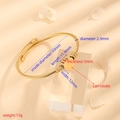 Gouden roestvrijstalen kabelarmband met draaibare hartvormige hanger en 59mm diameter - Kabel Door Hart-Goud