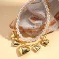 Detalle de collar de doble capa con perlas blancas y colgantes de corazón dorado - Dorado