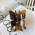 Elegante pinza para el pelo de mariposa marrón ámbar en acetato sobre una revista - Mariposa Con Hebilla De Caparazón De Tortuga Brillante Y Clara (aproximadamente 11 Cm)