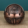 Bronze spherical Dubai ashtray featuring embossed landmarks and wooden table top - Red Copper Dubai Small