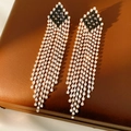 Detalle de aretes vintage con borlas de diamantes en una caja de cuero marrón - Pin de plata - Plata y Negro
