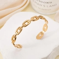 Polished gold chain-link cuff bracelet in stainless steel on a white stone base - Chain / Gold
