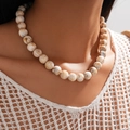 Close-up of marble-patterned beige and brown acrylic beads on a fashion necklace - Necklace / Brown