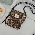 Détail d'un sac bandoulière en peluche léopard avec bandoulière corde sur table - Léopard en Velours d'Agneau Brun
