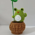 Handgefertigte grüne Strickfrosch-Puppe im braunen Häkel-Blumentopf mit Blatt - Topffrosch