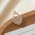 Macro shot of gold heart pendant with micro-paved zircons on a wooden display - Heart Lock Shape