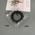 Macro view of clear PVC jewelry storage bag with 12cm black beaded bracelet inside - 30 Silk 12*12cm (100 Pcs)
