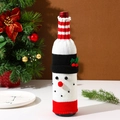 Detail of knitted snowman wine bottle cover with festive red and white striped accents - Snowman