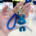Navy blue woven bear keychain with gold bell, ribbon bow, and braided leather strap - Blue Rabbit