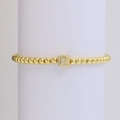 18k gold beaded elastic bracelet featuring a cube charm with letter L micro-inlay - Letter L