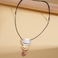 Dettaglio di pendenti ovali in metallo a tre toni su una collana con cordino nero - Oro Rosa-Stile Ovale A Tre Strati