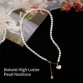 Natural freshwater pearl necklace with gold heart shell pendant on black velvet background - Heart Pendant Shell Pearl Necklace