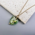 Close-up of green glass heart pendant necklace with gold foil accents on stone - Gold-Light Green
