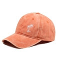 Close-up of washed orange baseball cap featuring white coconut tree embroidery - One Size / Orange